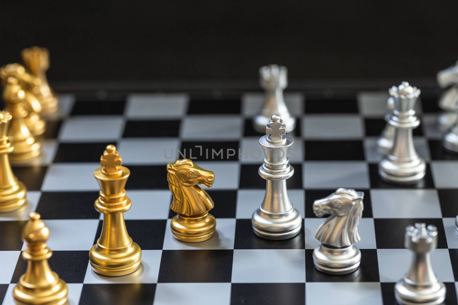 Chess game, set the board waiting to play in both gold and silver pieces detail blur
