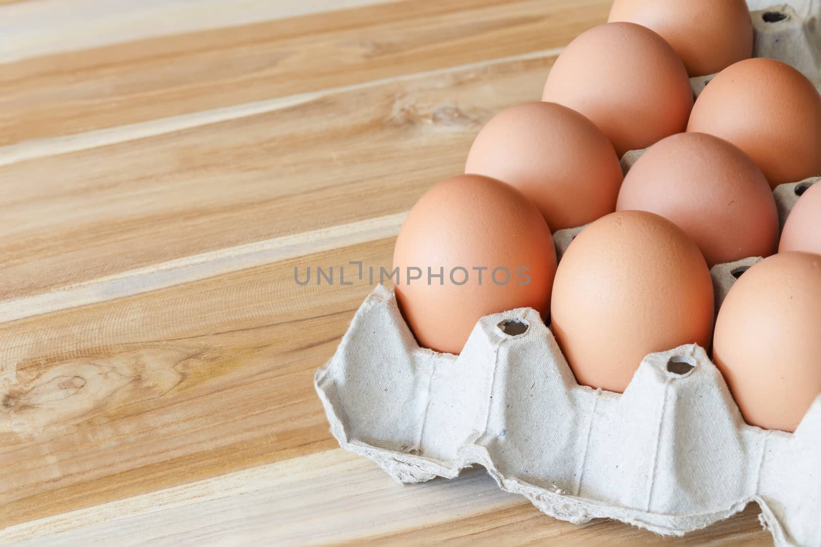 Fresh farm eggs on a wooden background by Natstocker