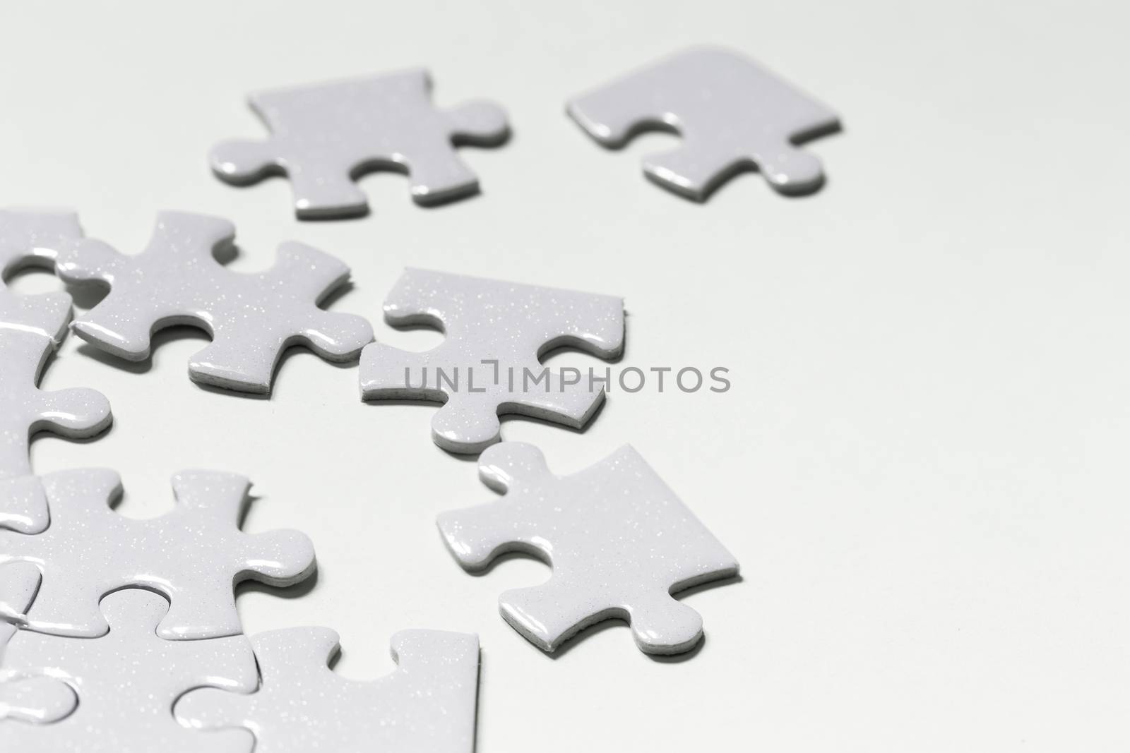 Jigsaw puzzle white piece on white backdrop by Natstocker