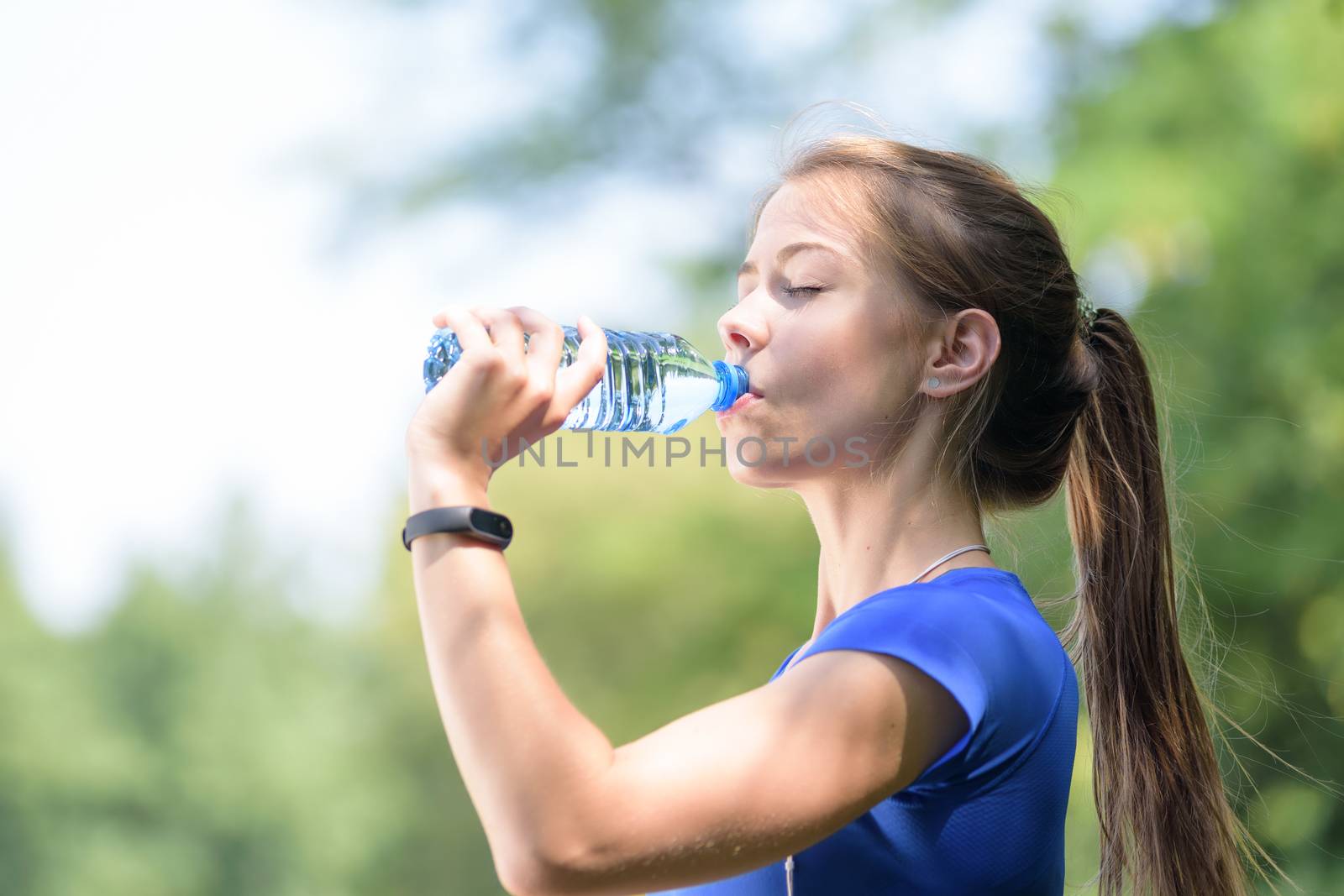 Athletic girl drinks water by wdnet_studio