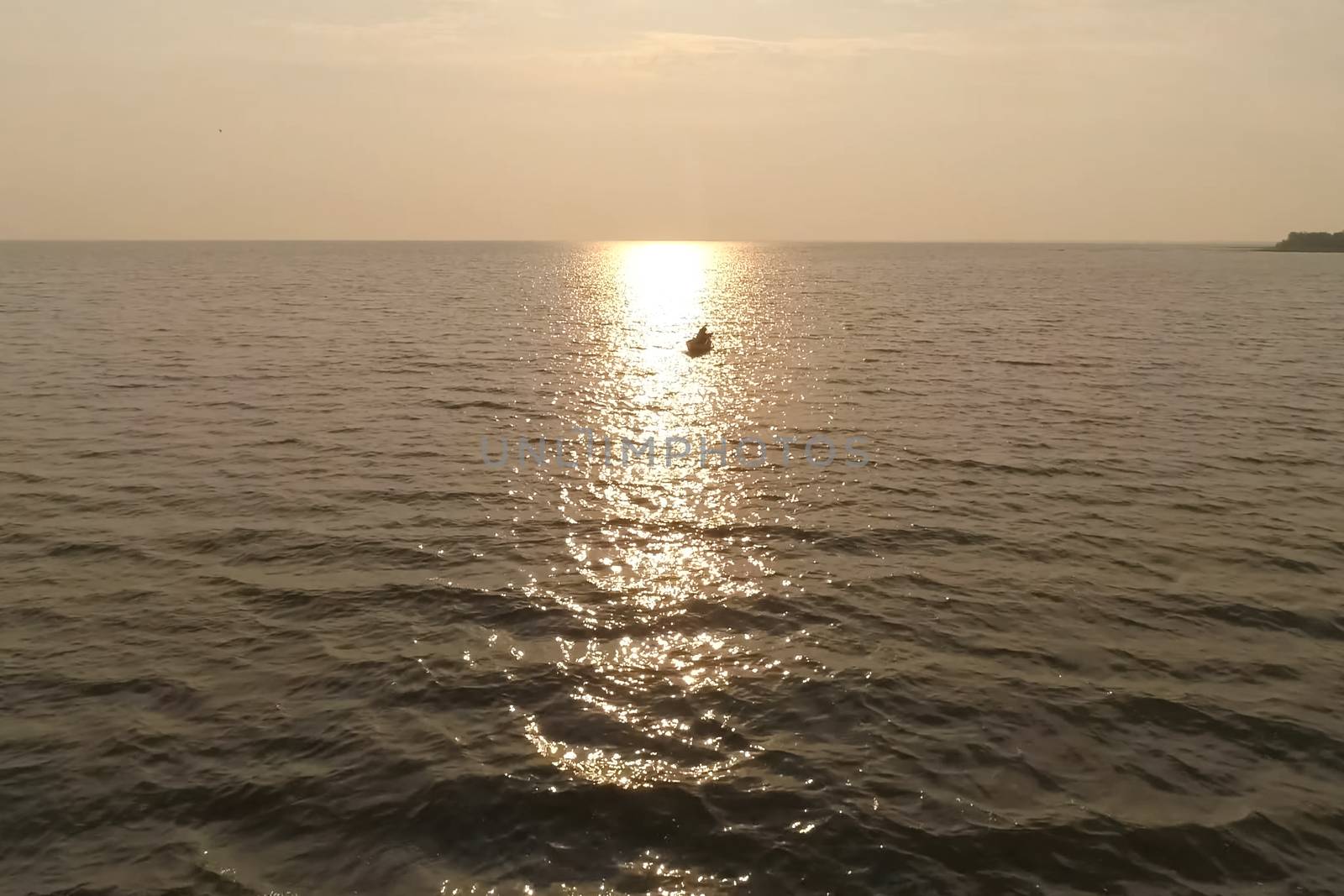 fisherman in a boat in the sea against the sunset. by DePo