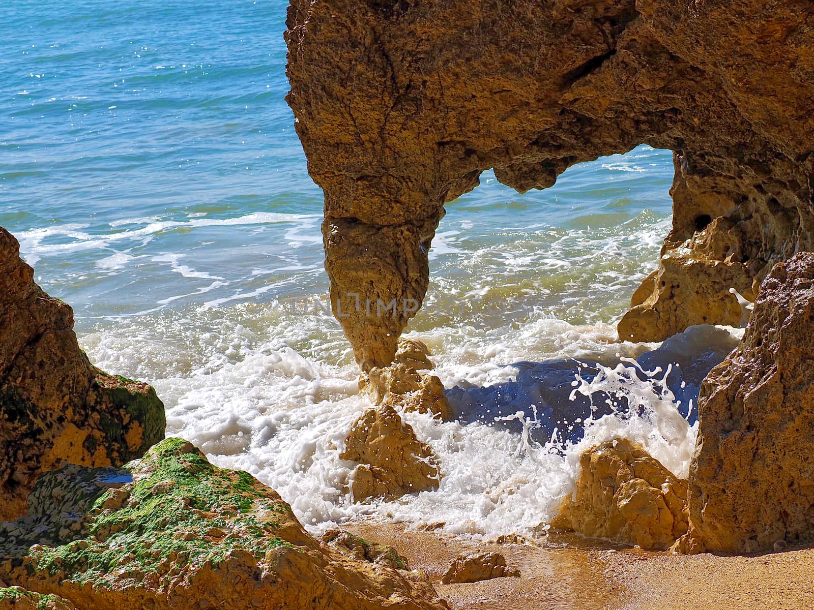 Red cliffs in blue sea at paradise beach Praia da Oura at the Algarve coast of Portugal