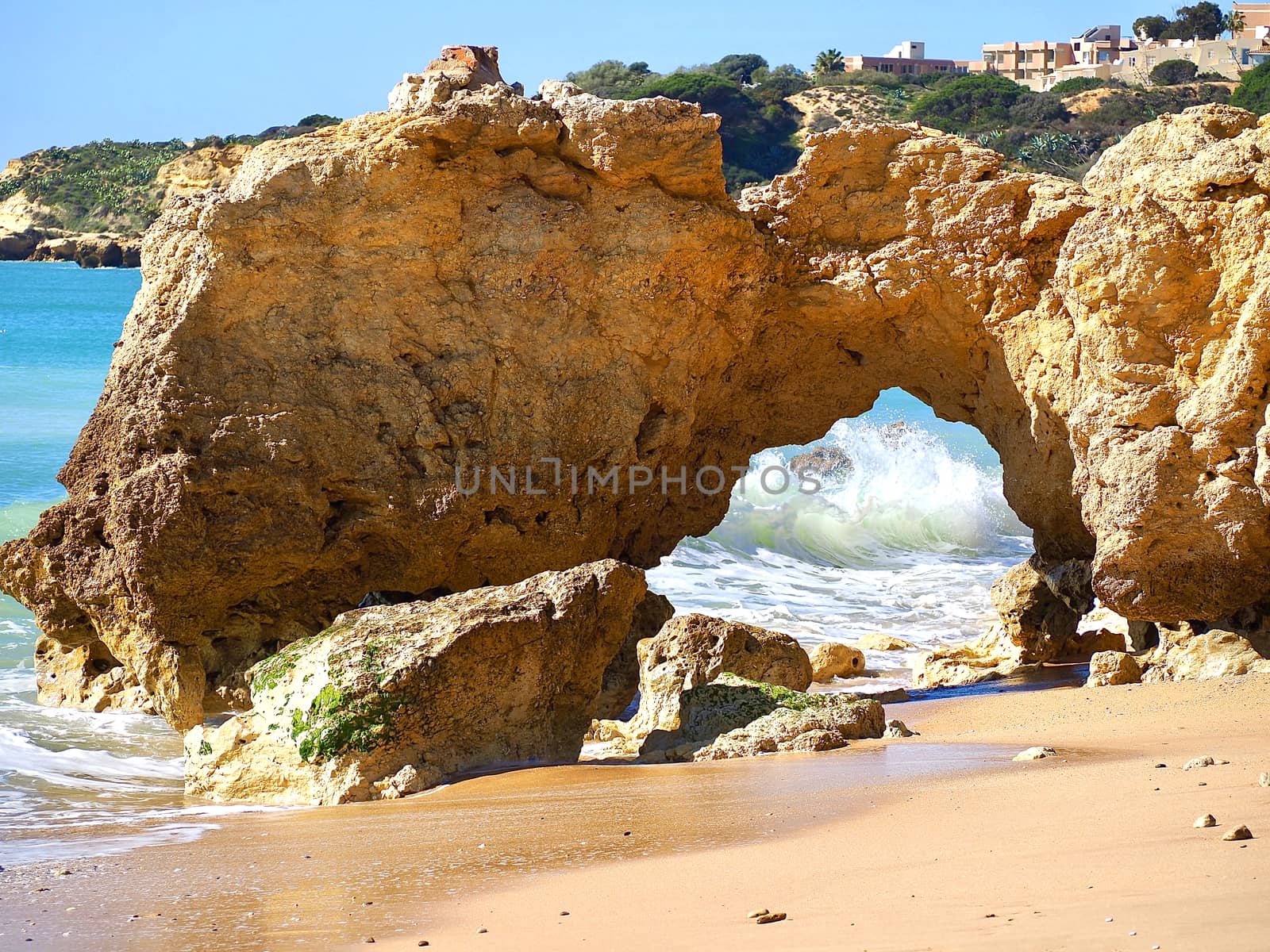 Red cliffs in blue sea at paradise beach Praia da Oura at the Algarve coast of Portugal