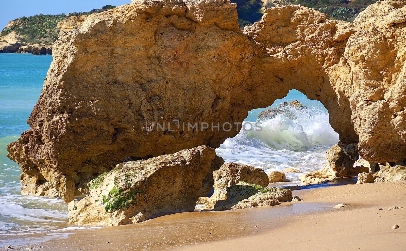 Red cliffs in blue sea at paradise beach Praia da Oura at the Algarve coast of Portugal