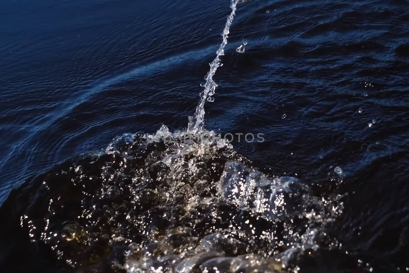 Spray in the water from the paddle. The surface of the water in the river.