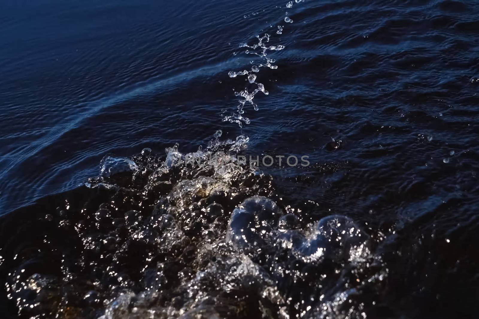 Spray in water from the paddle. The surface of the water in the river. by DePo