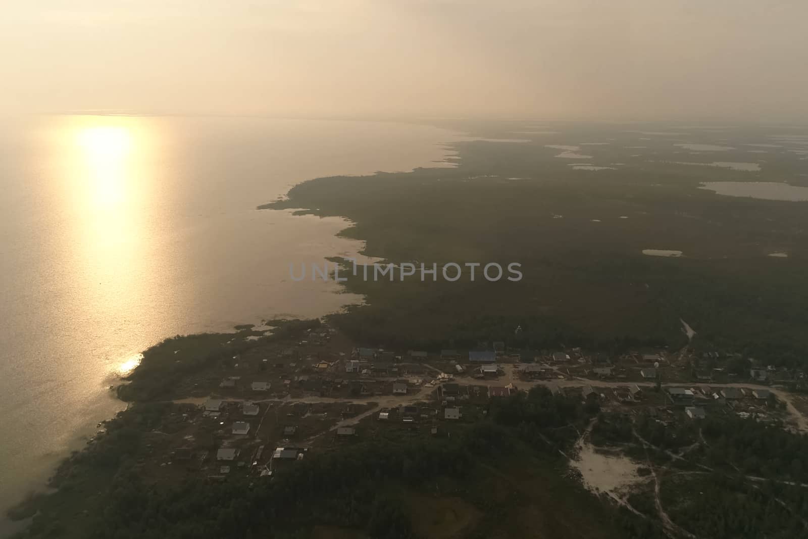 Sunny sunset over river and the village. Twilight over the village. by DePo