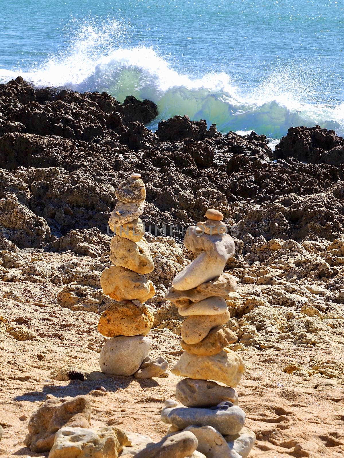 Stack of stones for balance and harmony in front of blue ocean