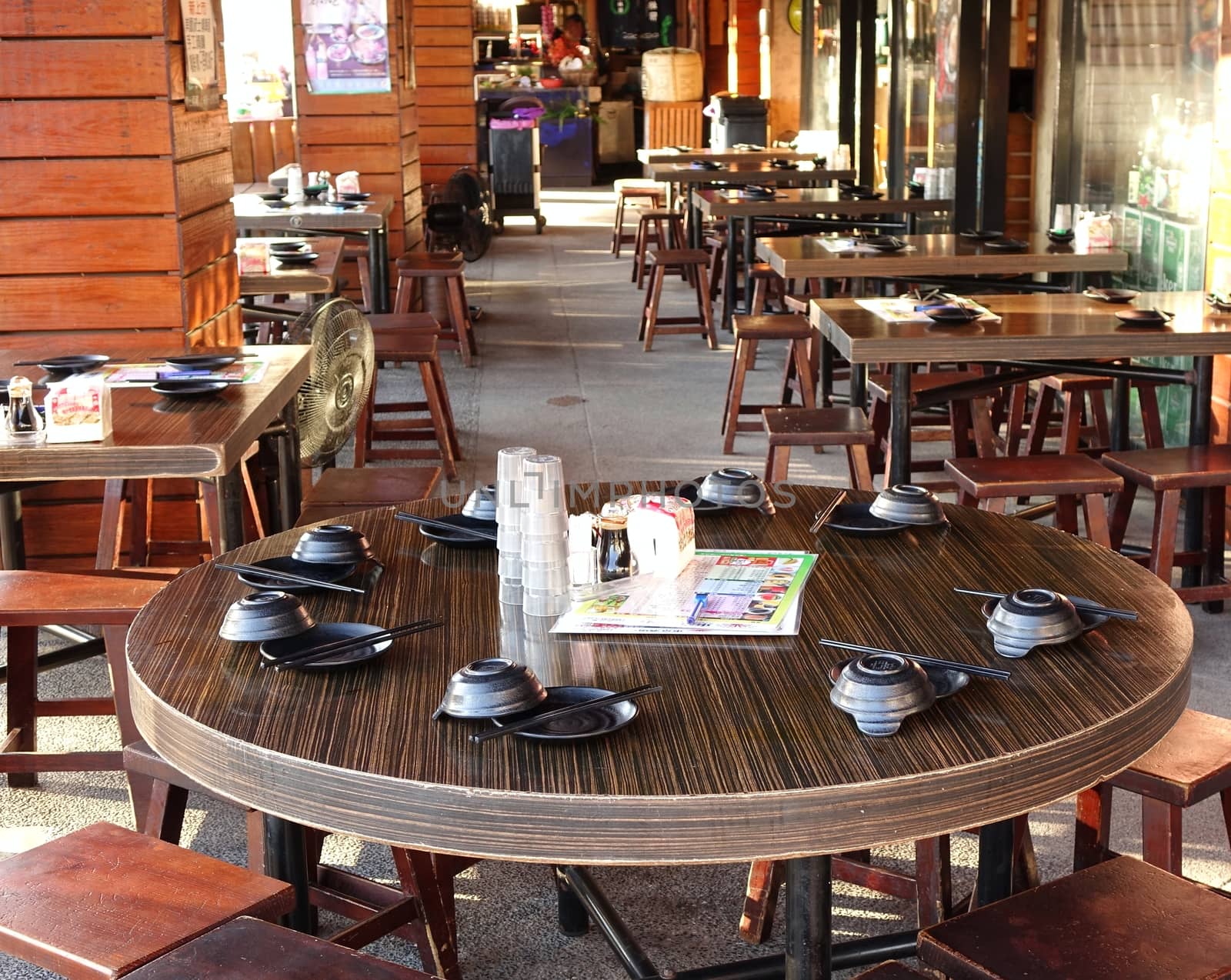 KAOHSIUNG, TAIWAN -- JUNE 17, 2015: A sidewalk restaurant has set up tables and stools for the afternoon and evening business.