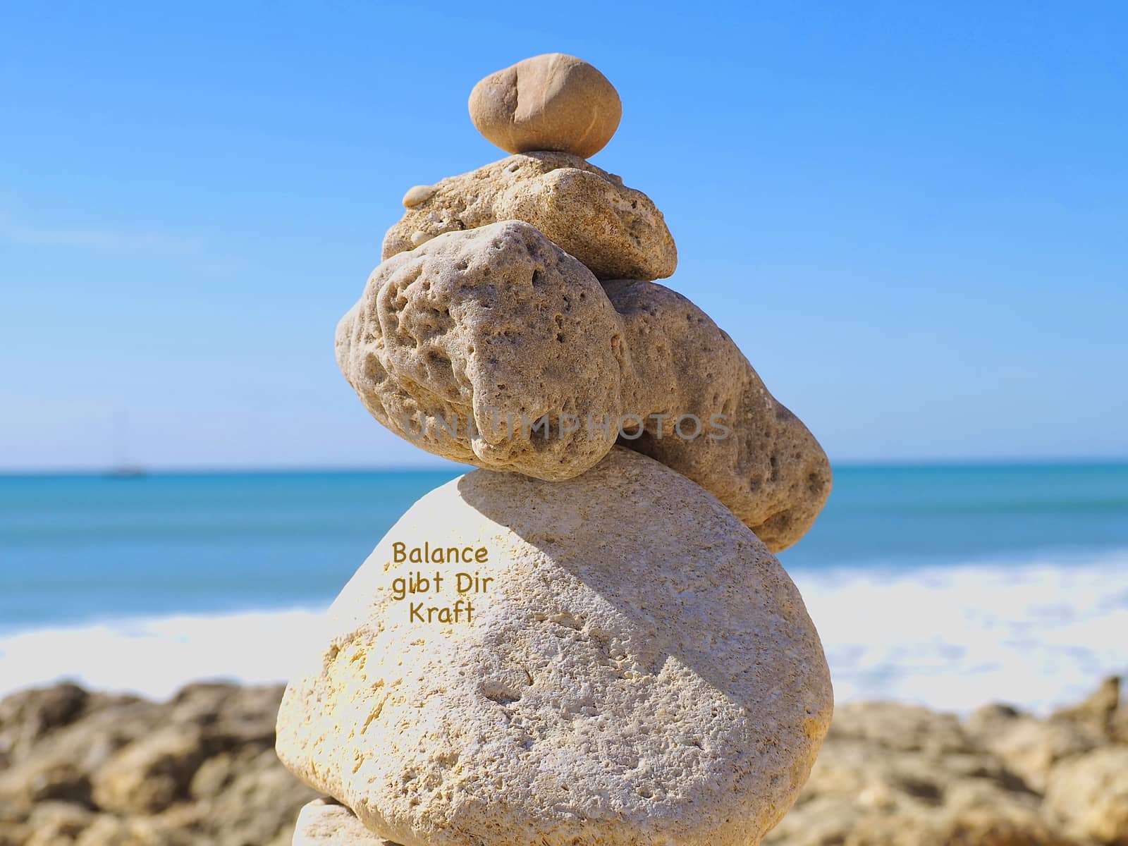 Stacks of stones in front of blue ocean by Stimmungsbilder