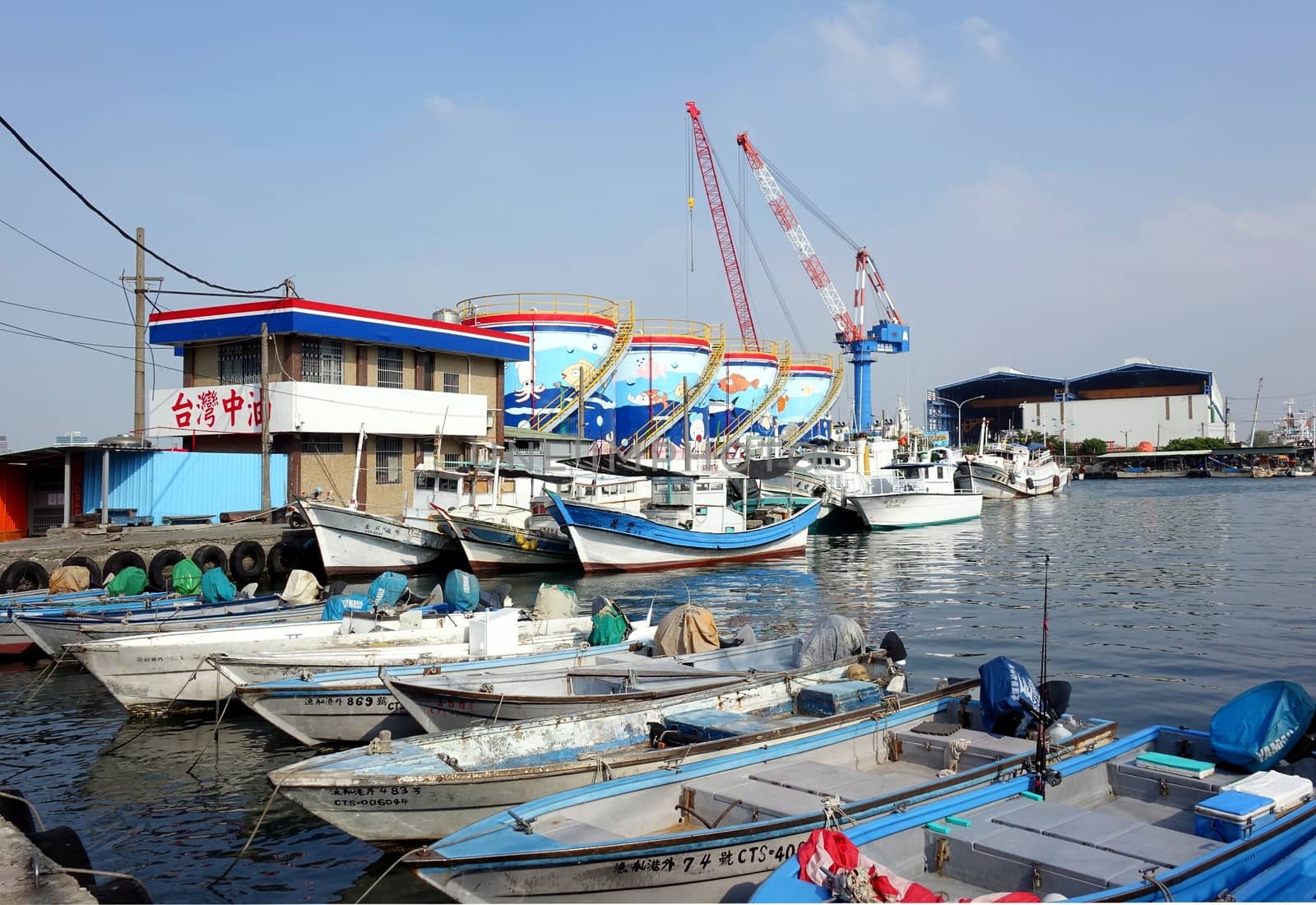 KAOHSIUNG, TAIWAN -- OCTOBER 11, 2014: A harbor for small fishing boats with storage tanks in the background on the island of Cijin.