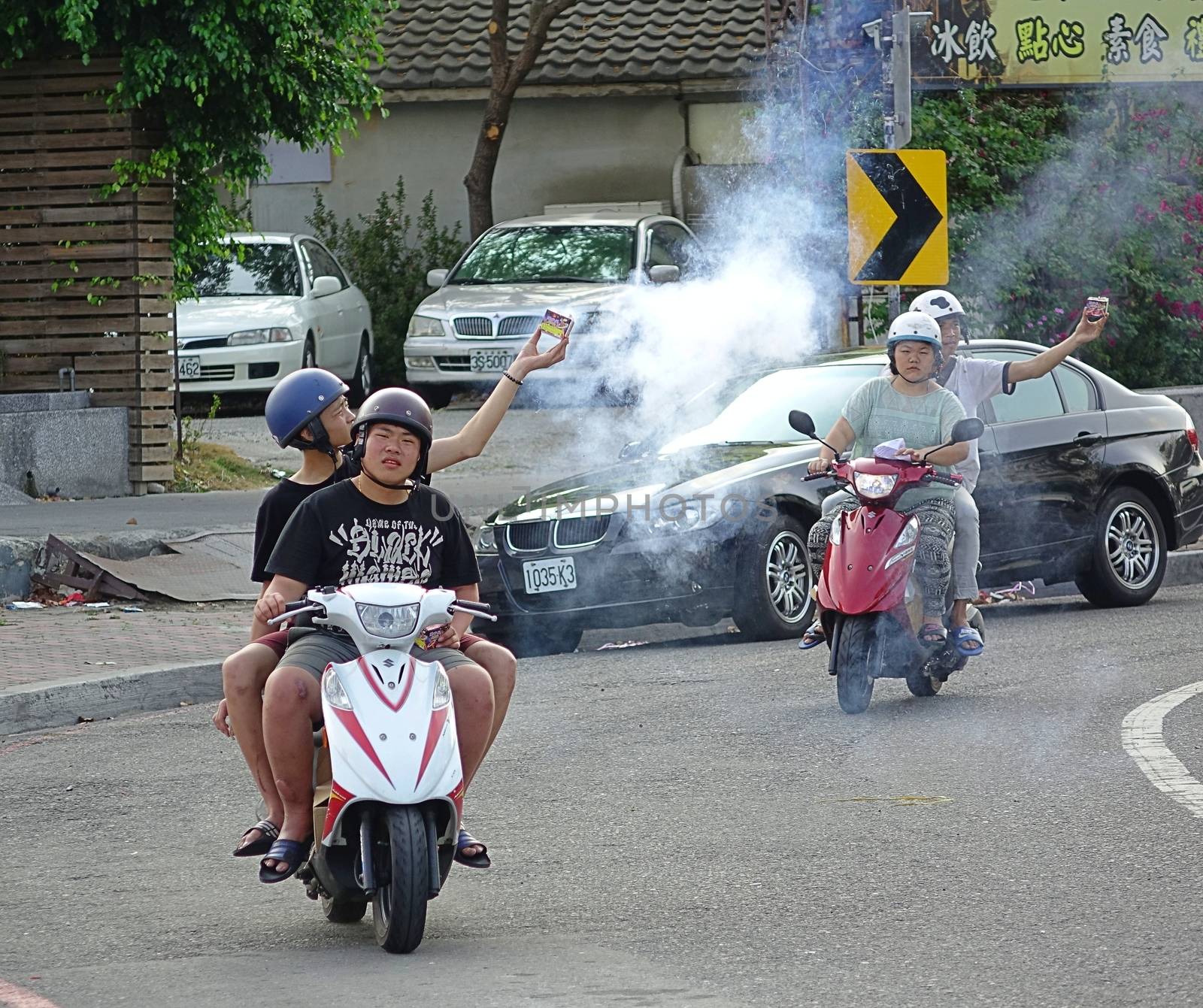 KAOHSIUNG, TAIWAN -- MARCH 29, 2014: Campain workers on scooters use firecrackers to announce the arrival of an election candidate in the run up to the 2014 local elections.