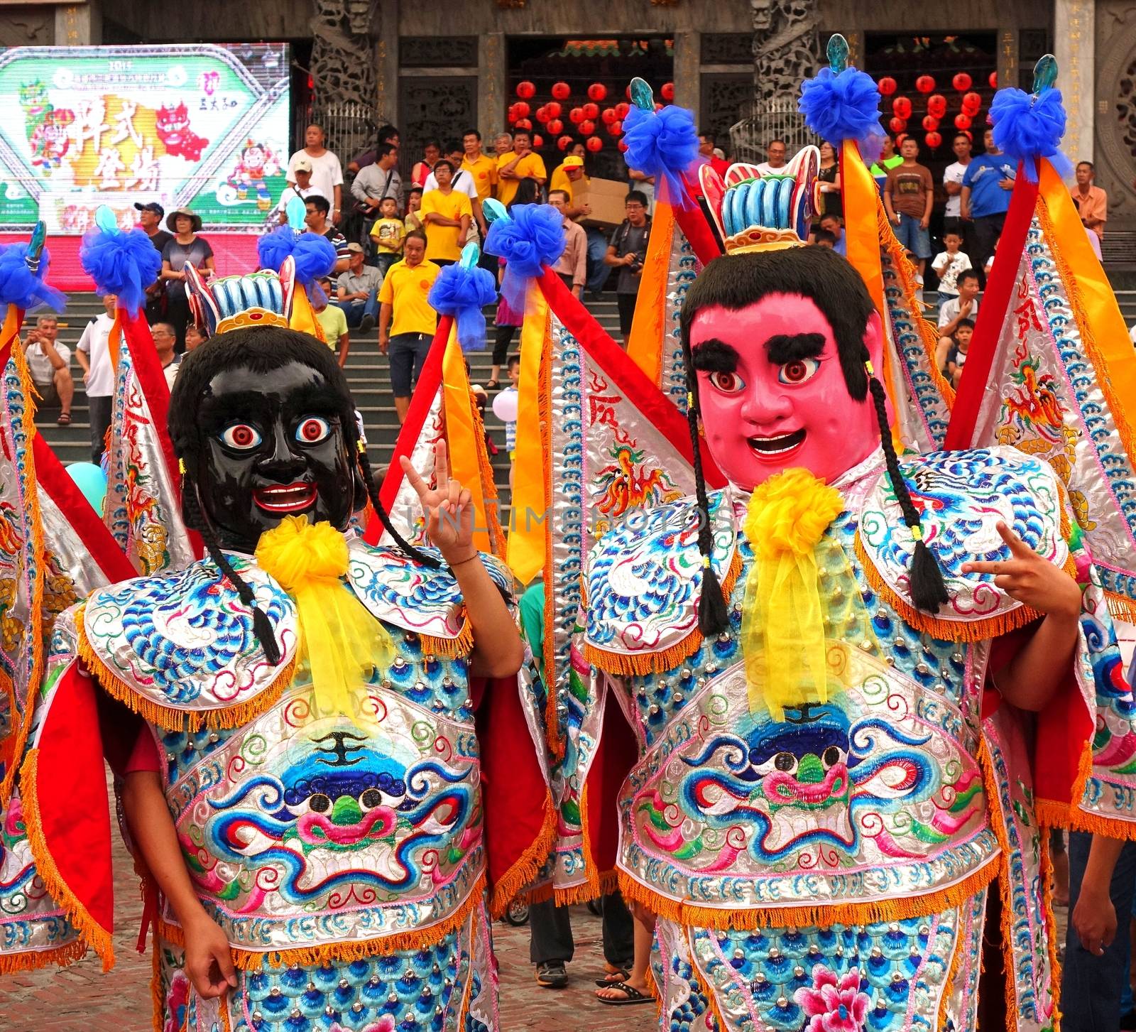 KAOHSIUNG, TAIWAN -- AUGUST 15, 2015: Two dancers in modernized costumes of the Chinese Third Prince tradition pose at a local temple carnival.