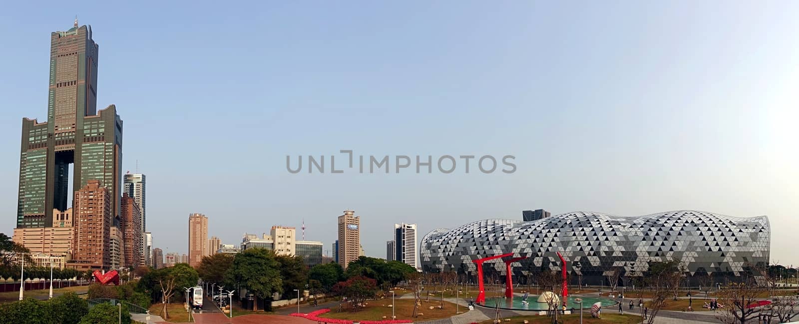 KAOHSIUNG, TAIWAN -- FEBRUARY 20, 2015: Panoramic view of the new Kaohsiung Exhibition Center with its unique waveform roof and the 85 story Tuntex Tower, the highest building in the city.
