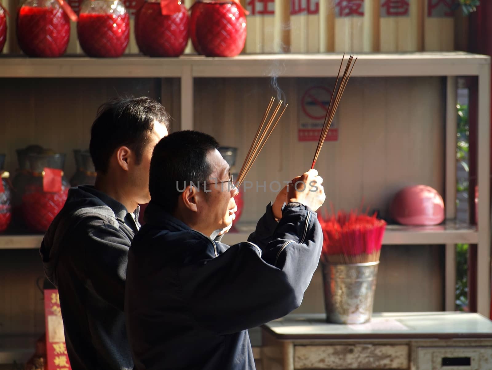 KAOHSIUNG, TAIWAN - FEBRUARY 10: Two unidentified men light incense sticks and say prayers for the Chinese New Year on February 10, 2013 in Kaohsiung.
