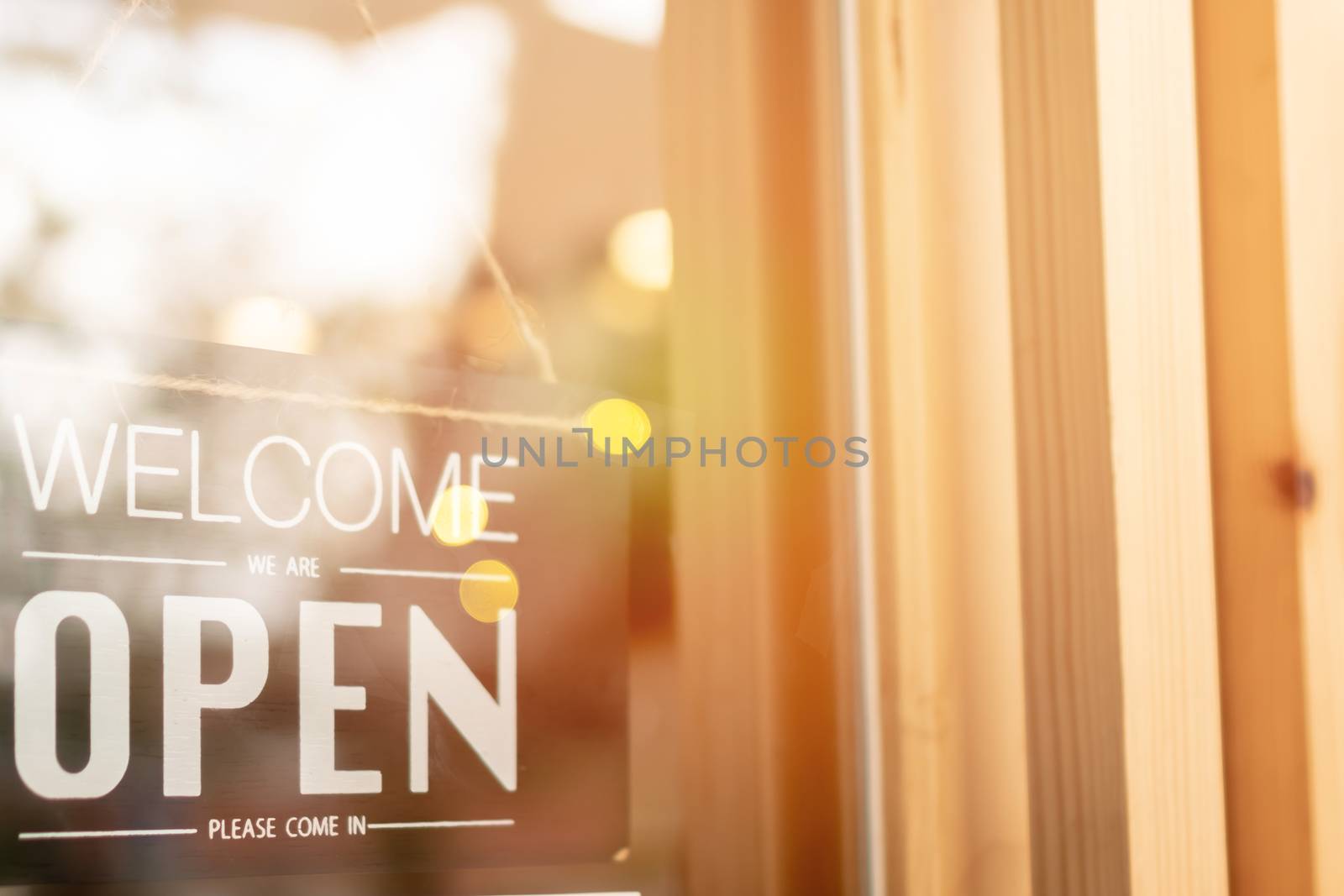 Open sign vintage style at coffee cafe shop with sunrise and bokeh. Metaphor of start or begin a own business. 