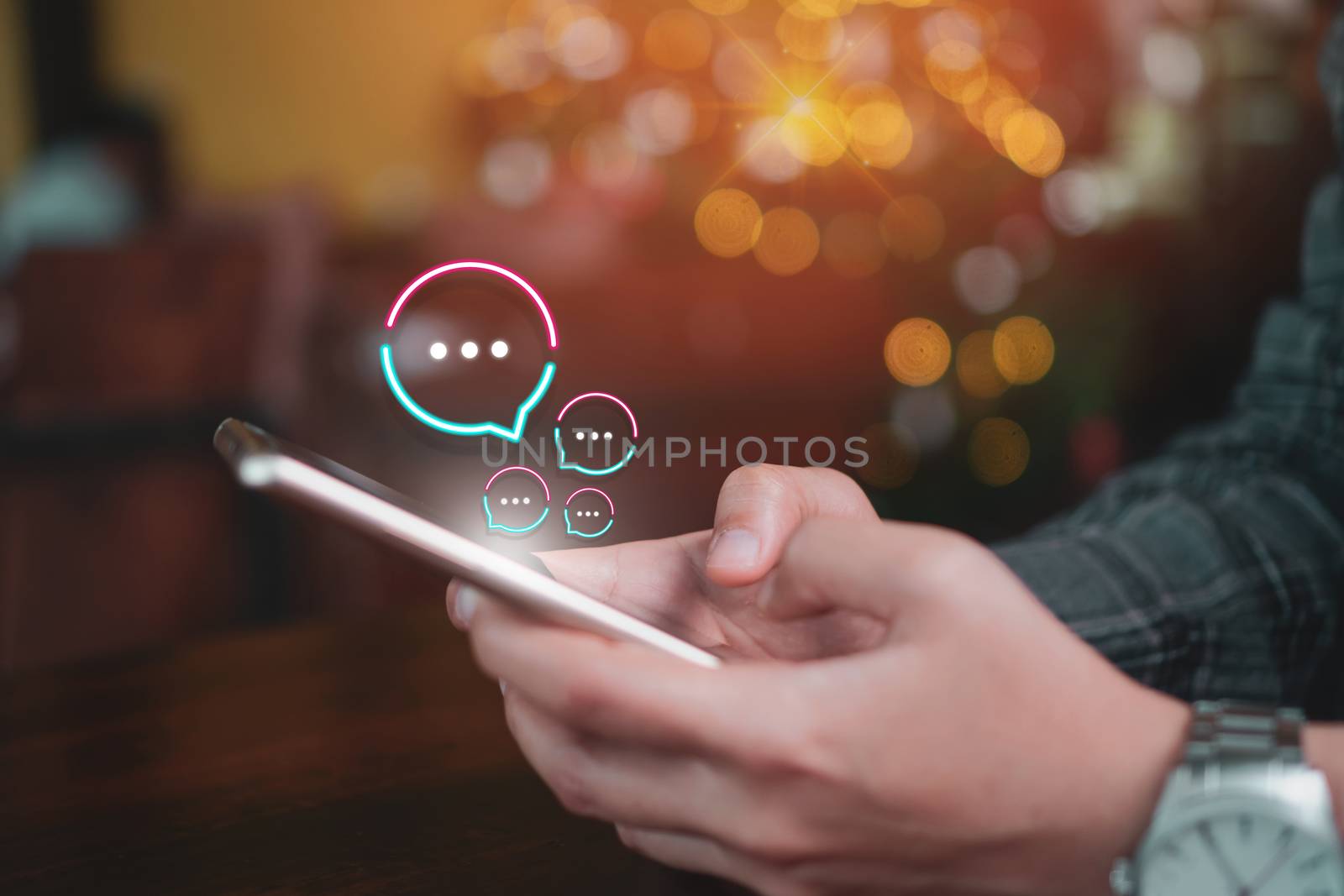 People hand using smartphone typing, chatting or text  messages in chat icons pop up. Social media maketing technology concept. Vintage soft color tone background.