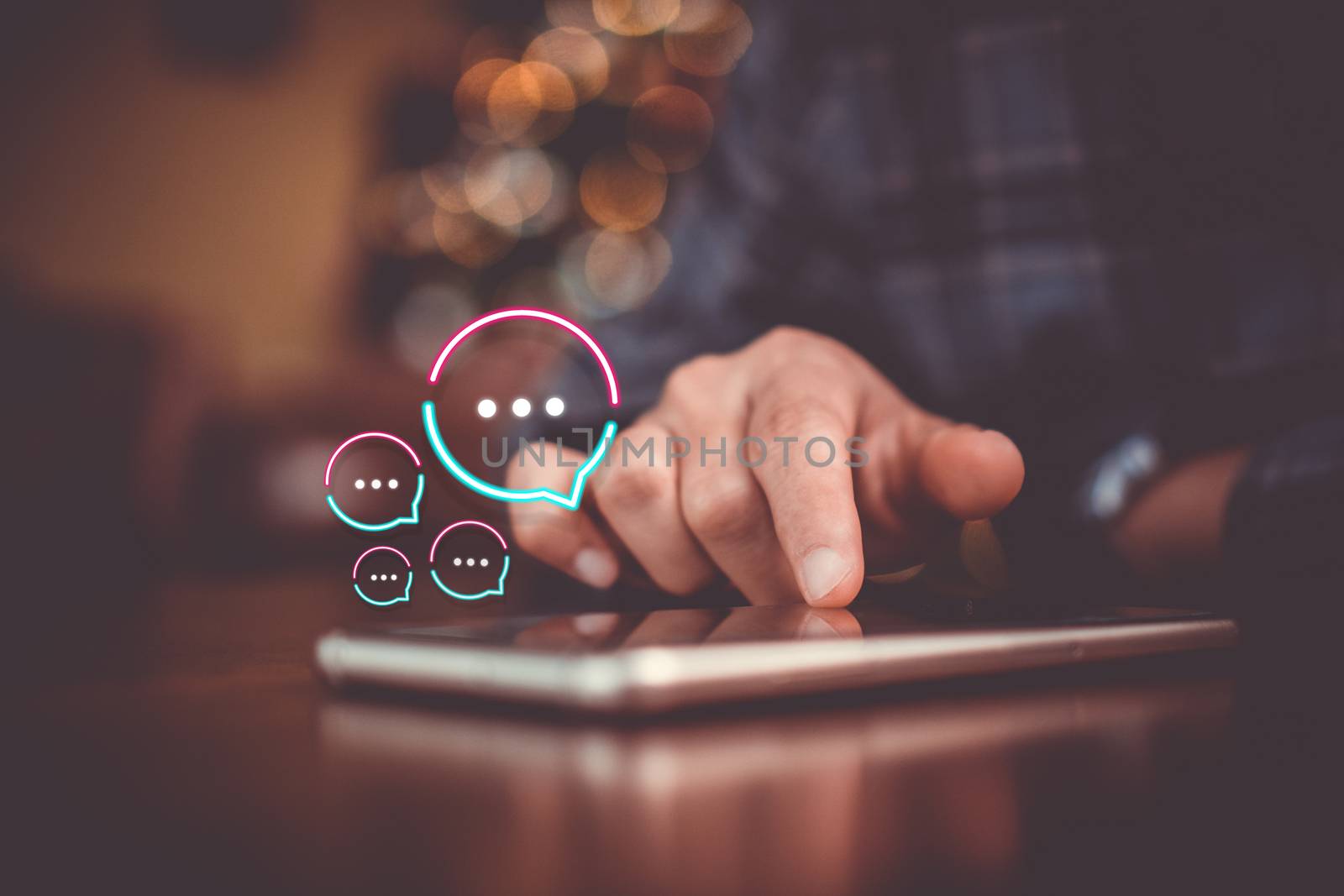 People hand using smartphone typing, chatting or text  messages in chat icons pop up. Social media maketing technology concept. Vintage soft color tone background.