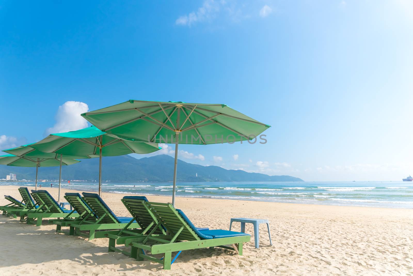 Beach chairs with outdoor umbella at summer beach with blue sky.