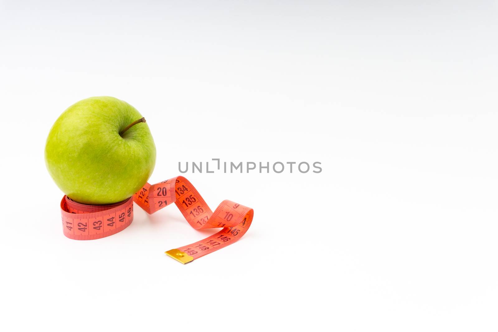 Green apple with red measuring tape. Health care and body fitness concept