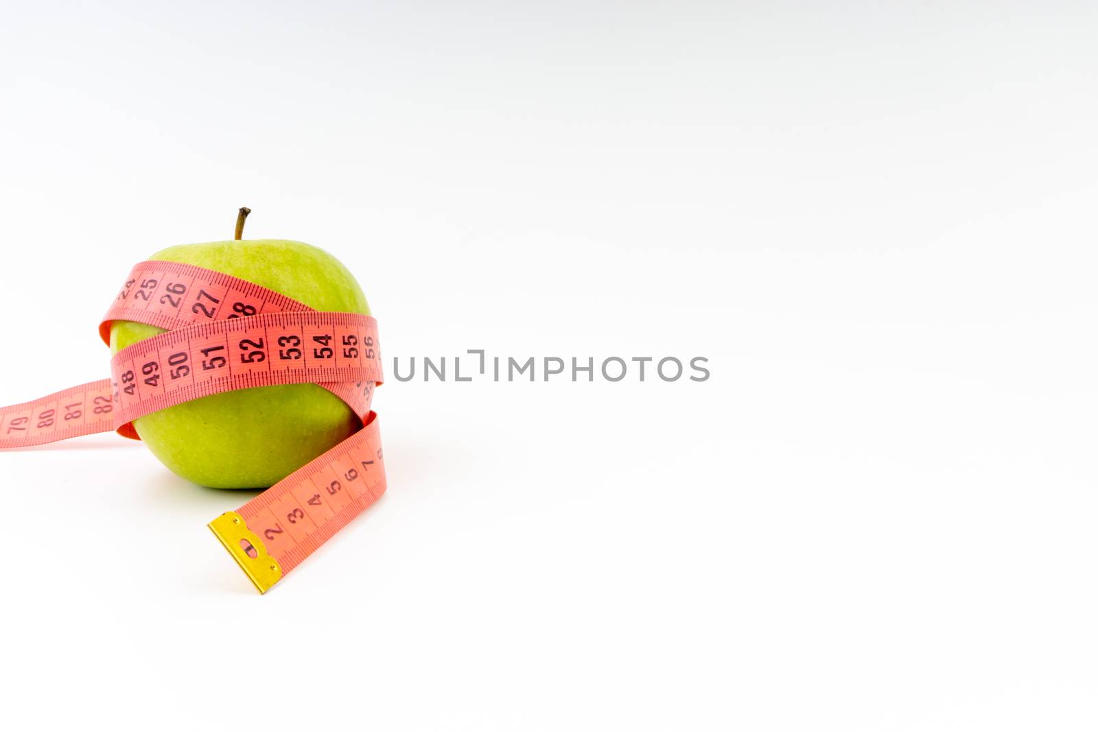 Green apple with red measuring tape. Health care and fitness concept by silverwings