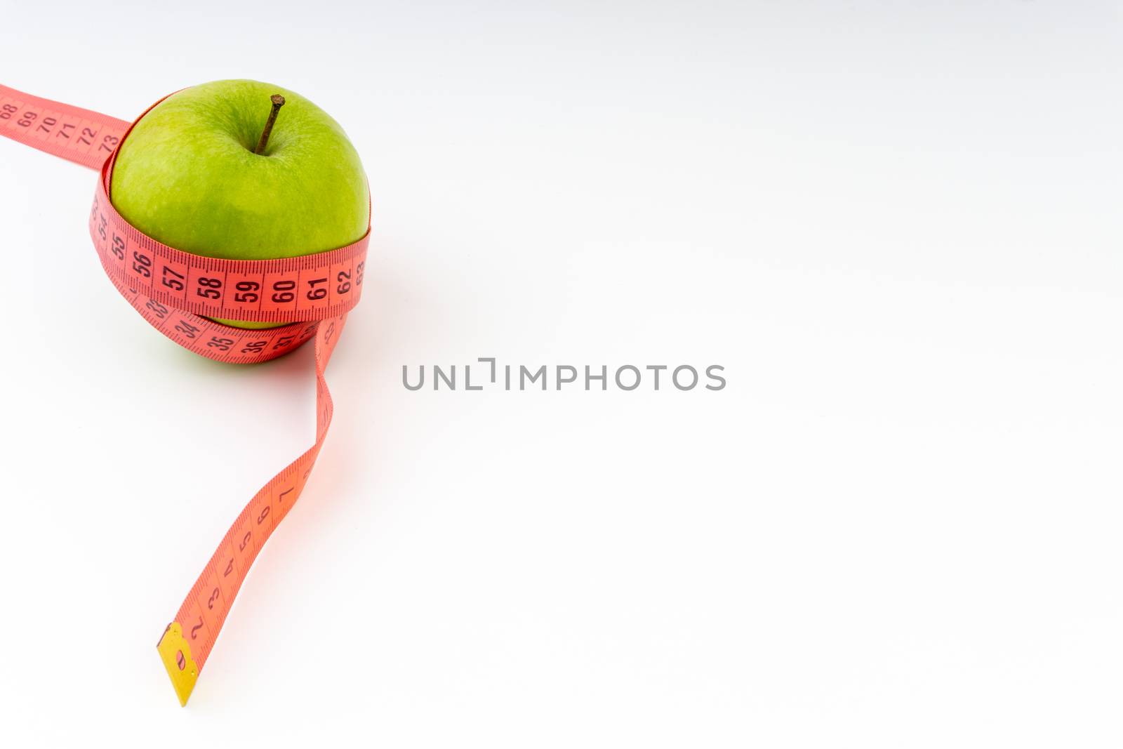 Green apple with red measuring tape. Health care and body fitness concept