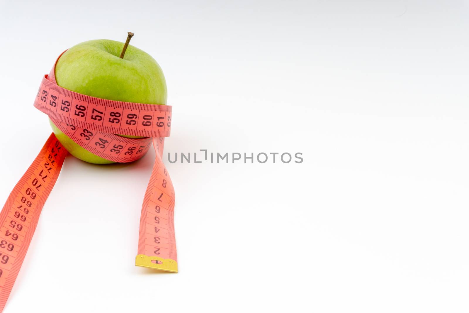 Green apple with red measuring tape. Health care and body fitness concept