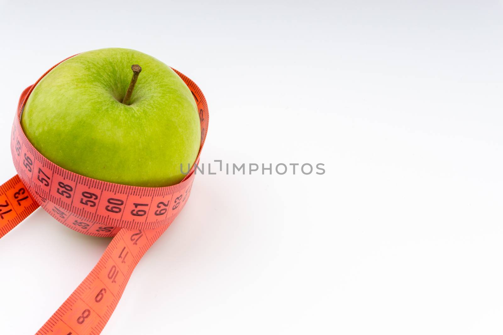 Green apple with red measuring tape. Health care and fitness concept by silverwings