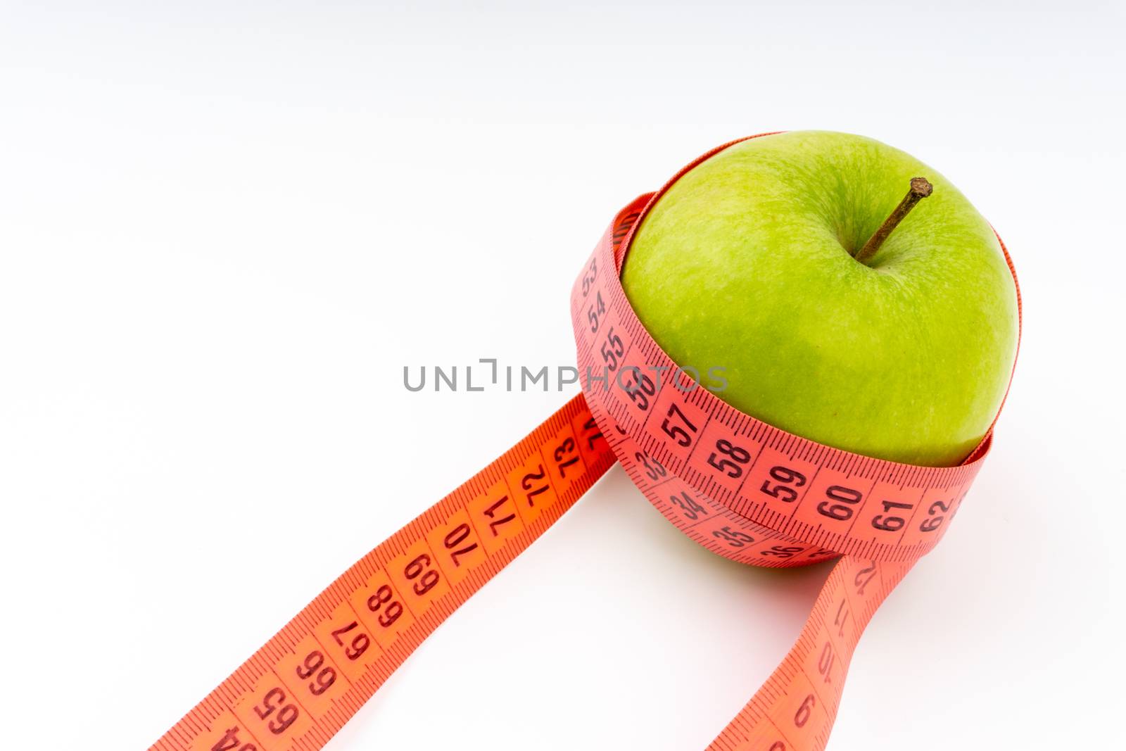 Green apple with red measuring tape. Health care and fitness concept by silverwings