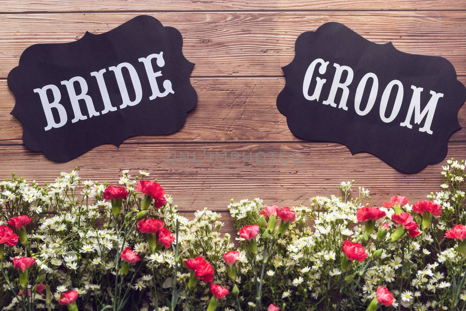 Bride and Groom text sign on wooden background decorated with flower, vintage style. wedding invitation and greeting card