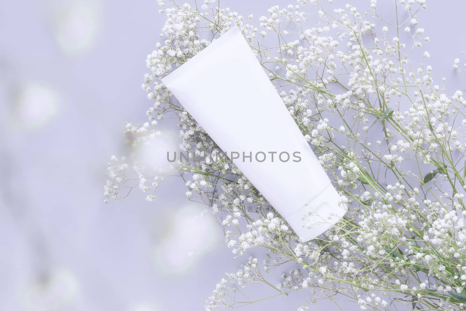 cosmetic nature organic skincare concept. whitening cosmetic in white tube container with blank label for branding packaging mock up, decorate with white flower with copy space