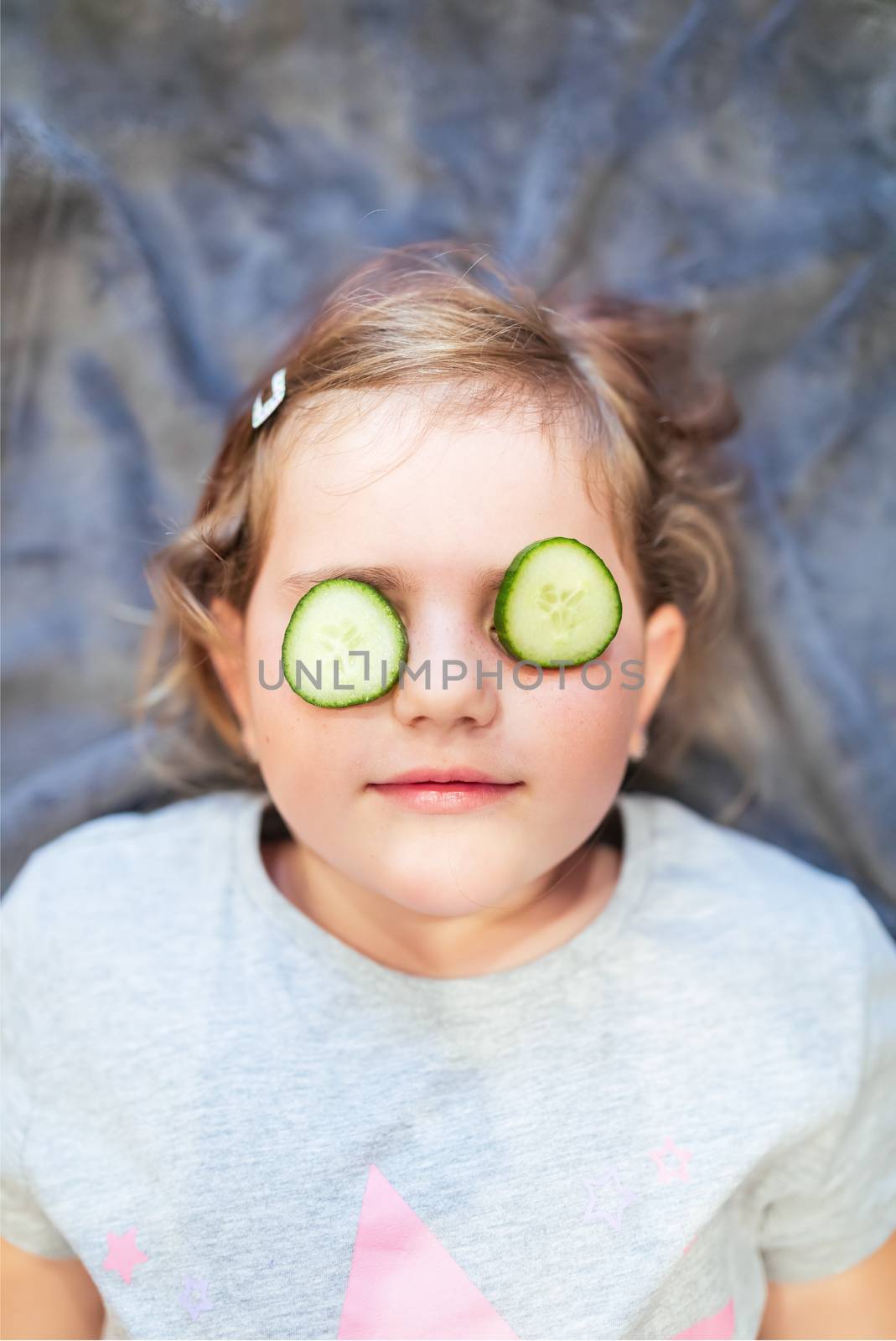 Funny small girl with piece of cucumber by artush