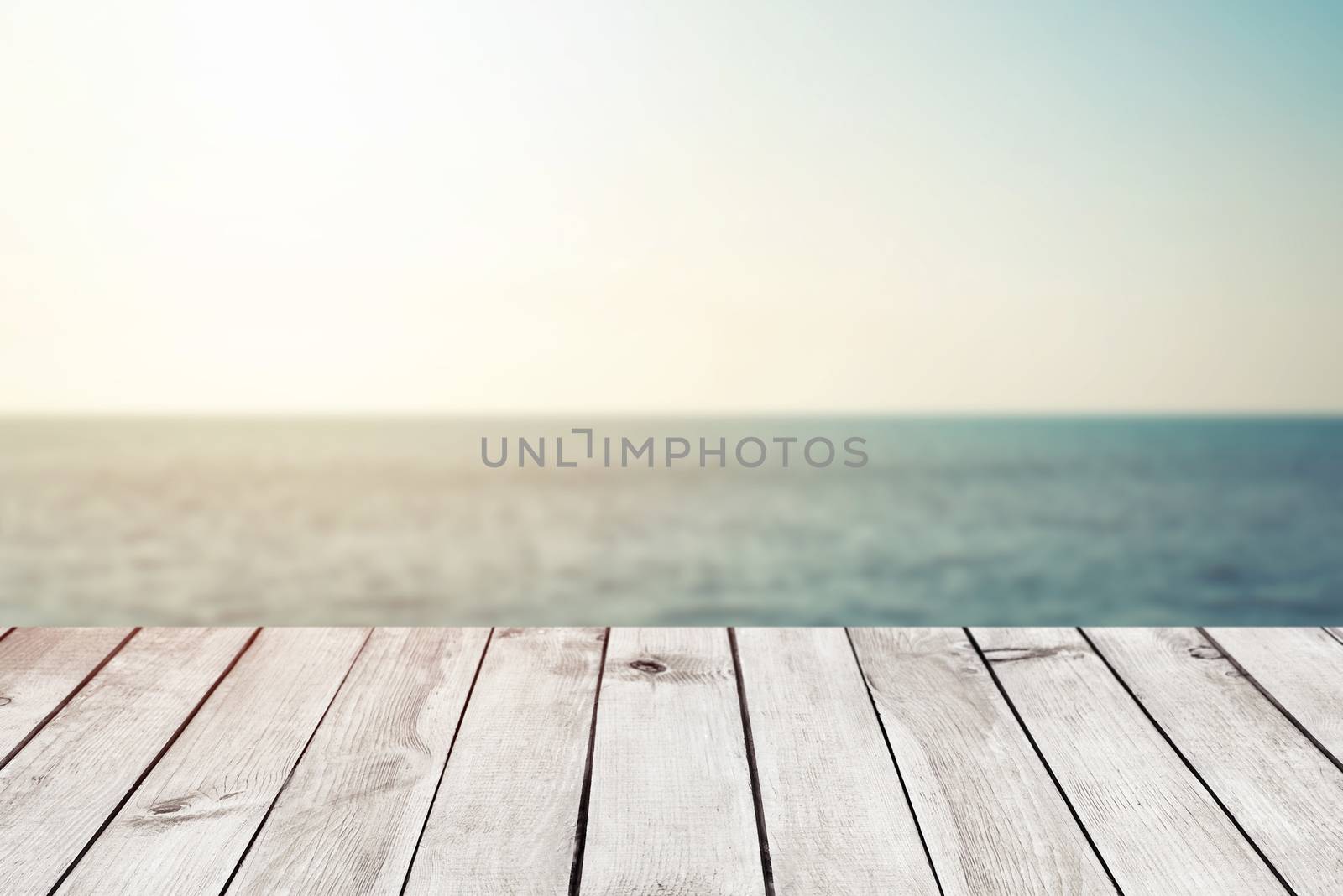 Empty wood table top on blur abstract sea beach background with sunlight, for montage product display