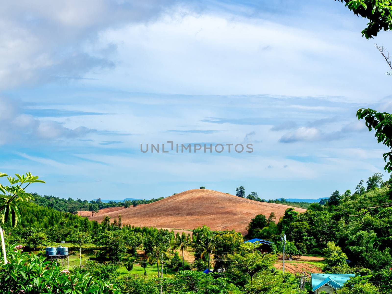 Beautiful bald mountain stand out surround with landscape view with many fresh green tree and blue sky on countryside.