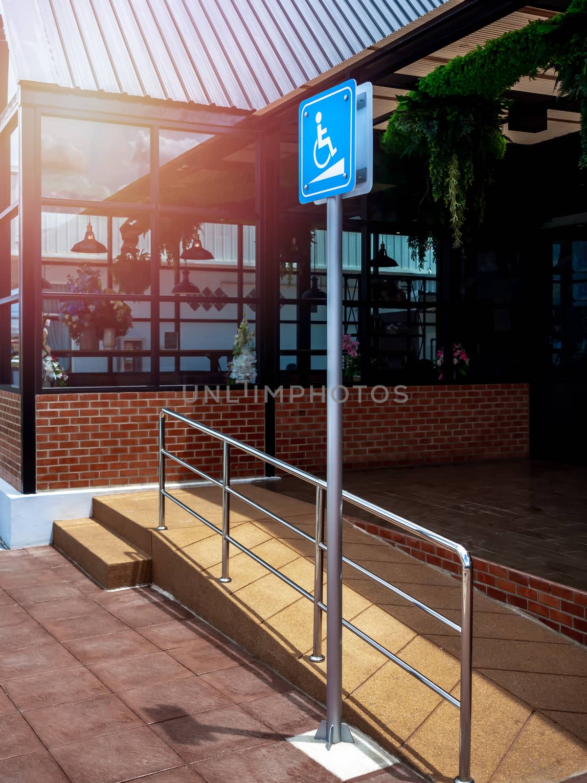 Disabled way sign in front of building, vertical style. Wheelchair ramp way with disabled sign for support wheelchair disabled people.