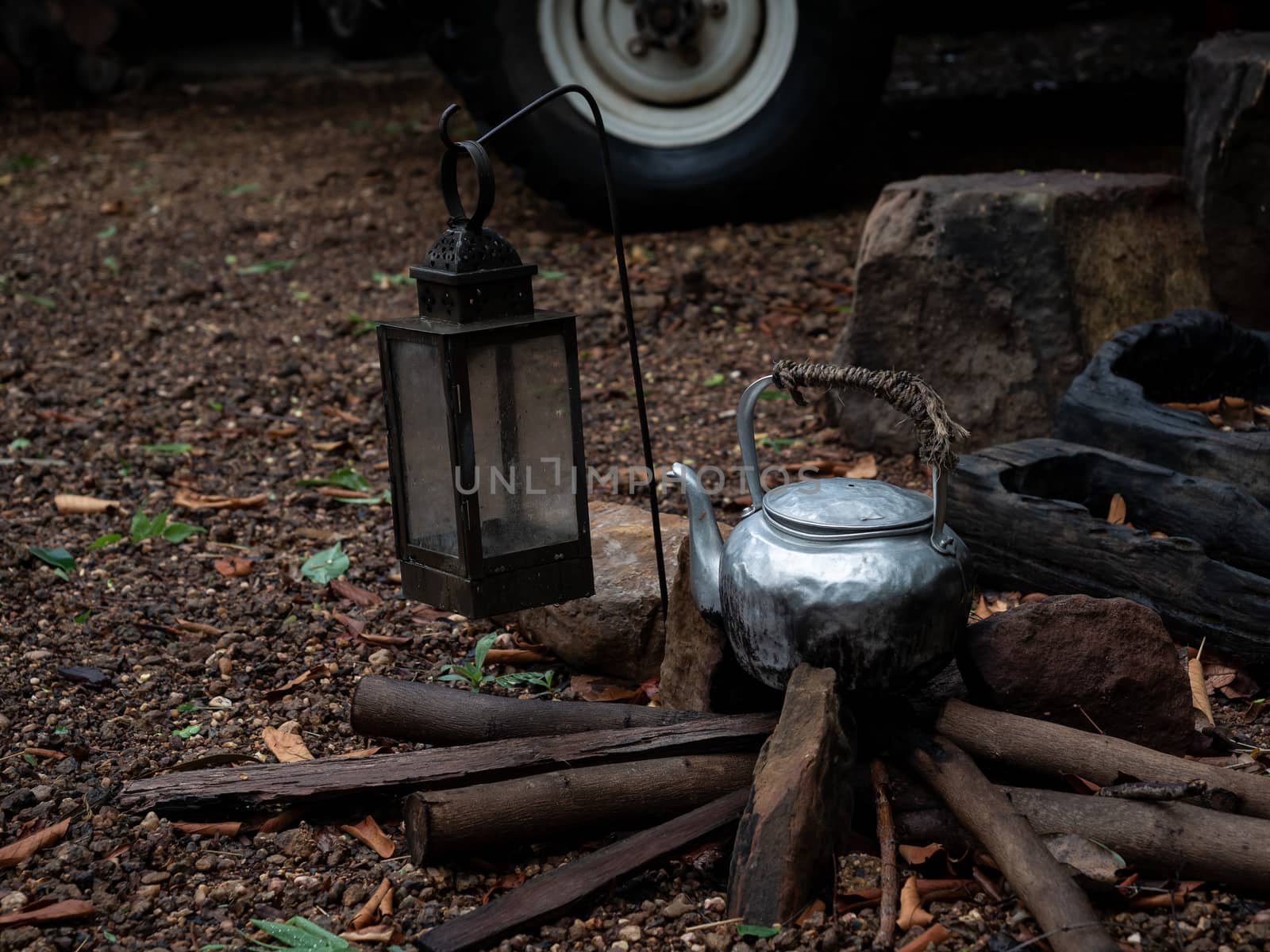 Old kettle on wood in camping outdoor in rainforest background.
