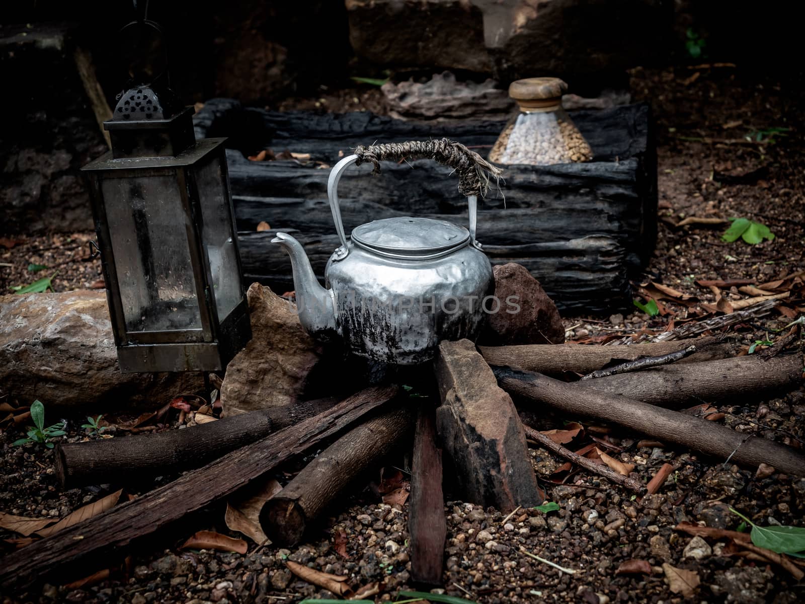 Old kettle on wood in camping outdoor in rainforest background.