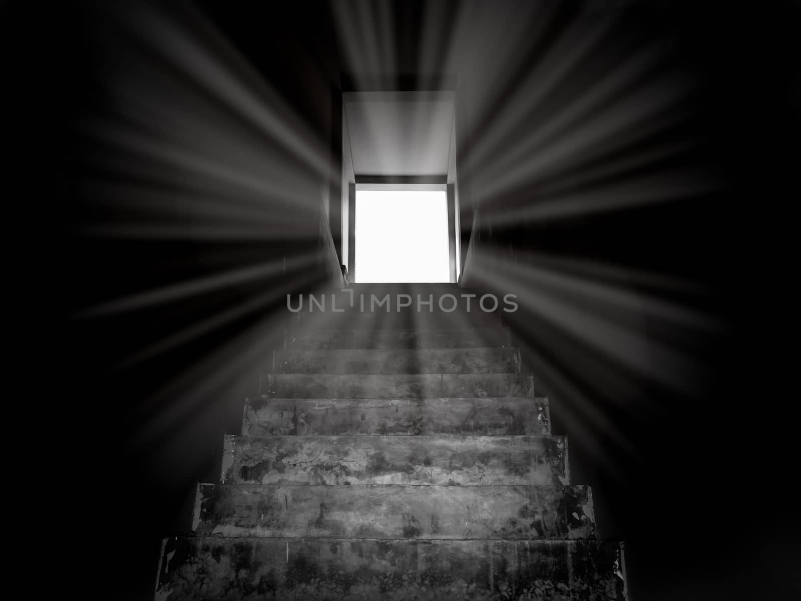 Old concrete stairs to secret door with the light, way to success. Step up stairway, from the dark to the shining light, black and white style.