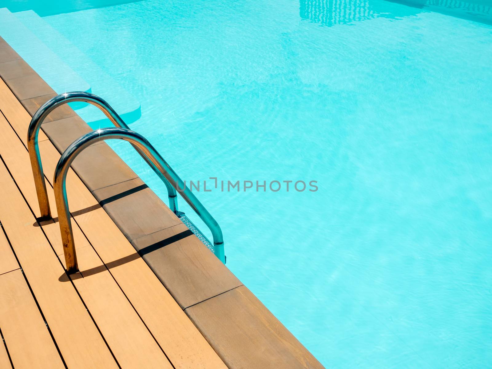 Outdoor swimming pool background minimal style. Grab bars ladder in the blue swimming pool with copy space.