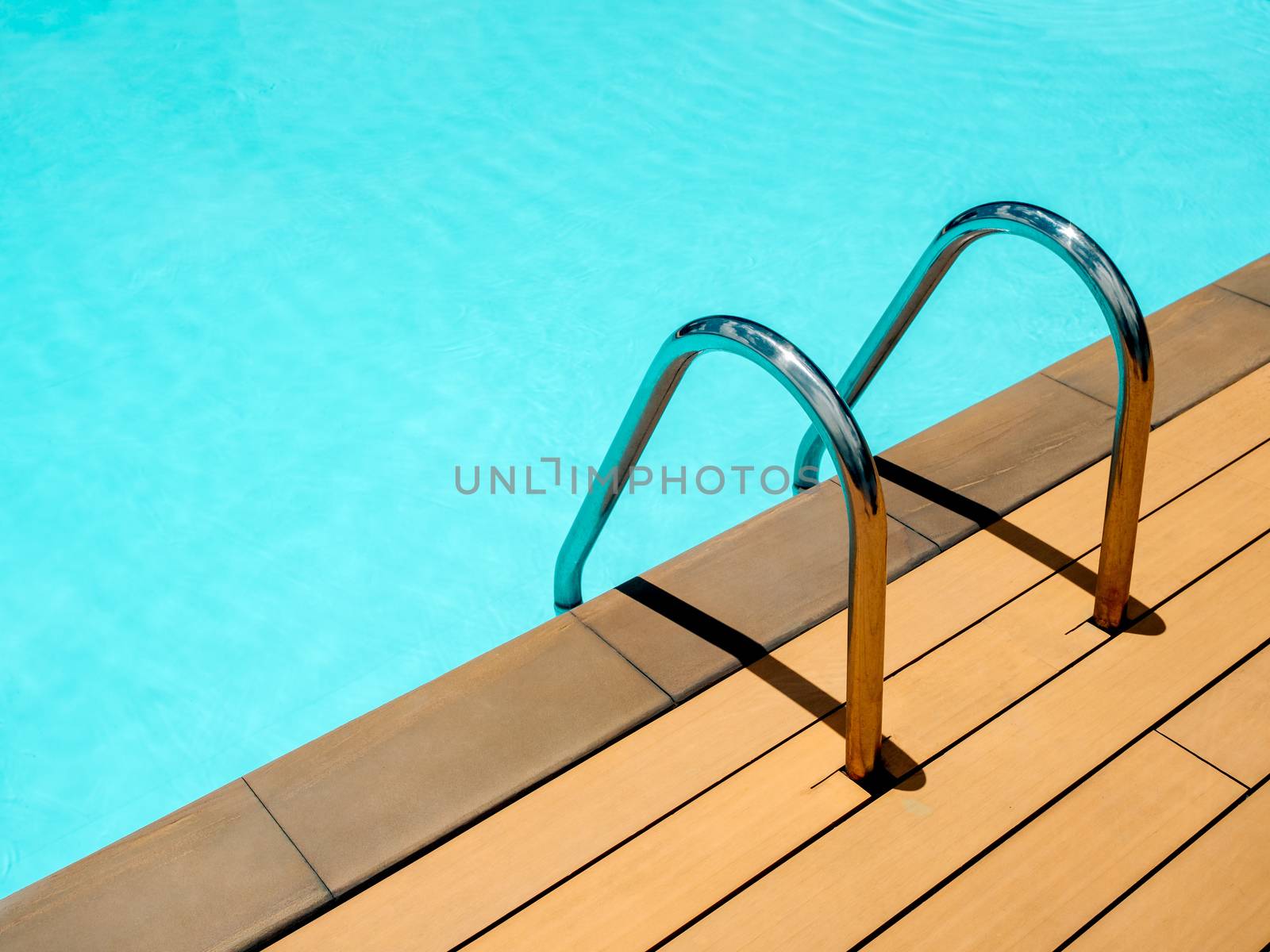 Outdoor swimming pool background minimal style. Grab bars ladder in the blue swimming pool with copy space.