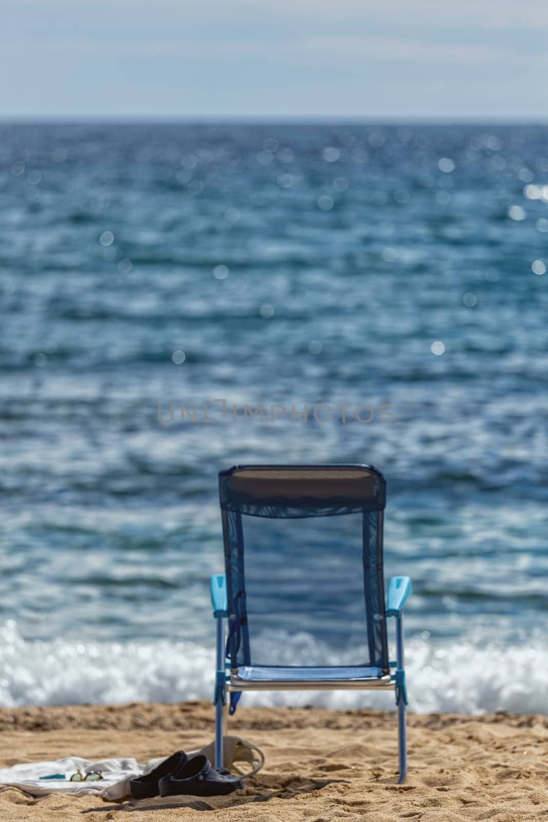 Chair on the beach without people by Digoarpi