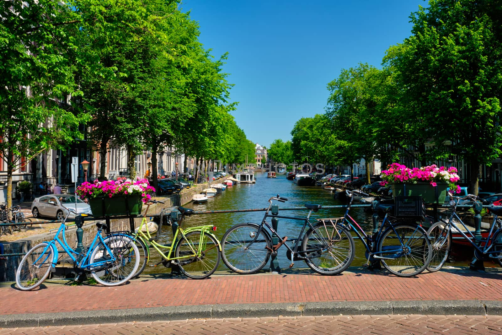 Typical Amsterdam view - Amsterdam canal with boats and bicycles on a bridge with flowers. Amsterdam, Netherlands