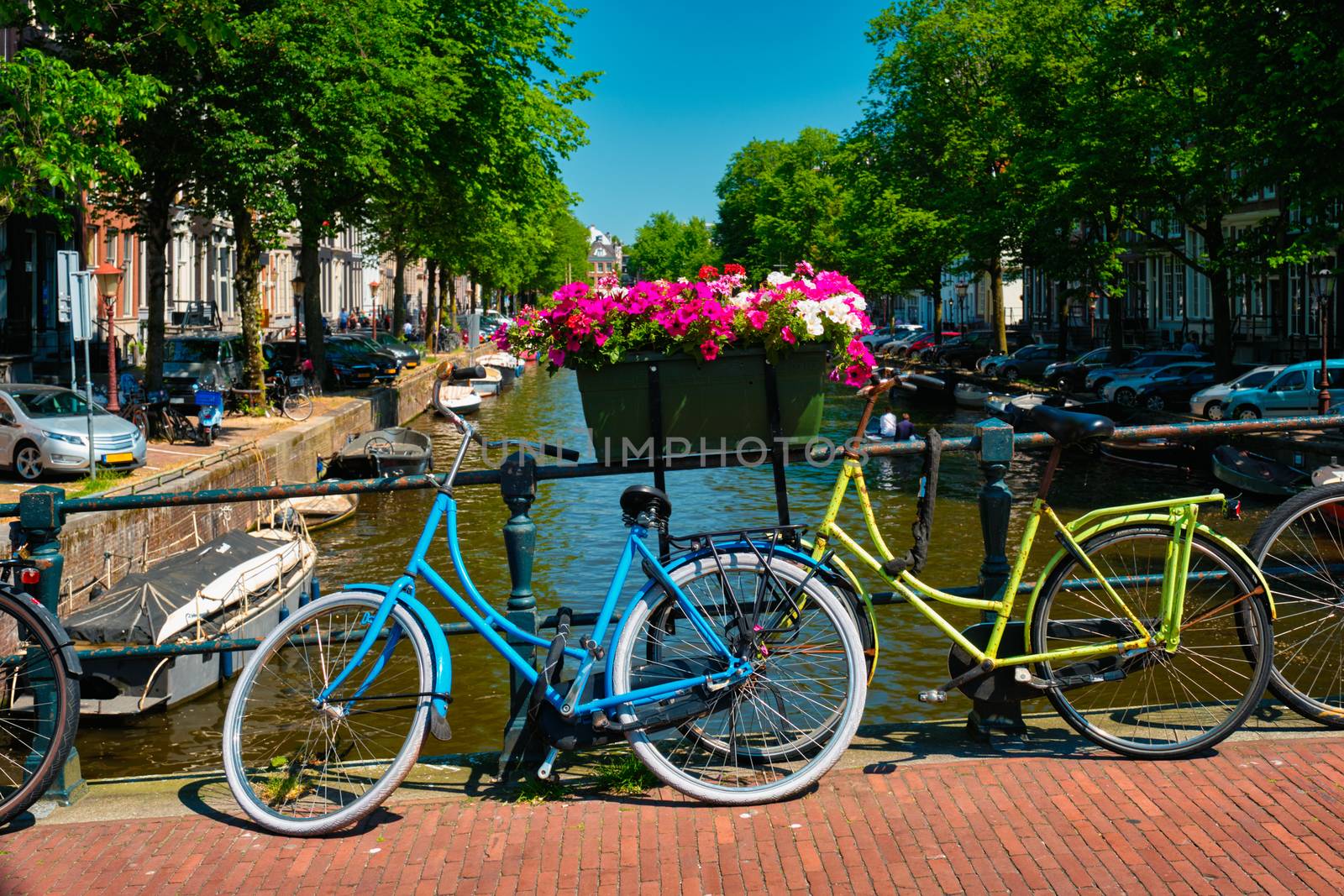 Typical Amsterdam view - Amsterdam canal with boats and parked bicycles on a bridge with flowers. Amsterdam, Netherlands