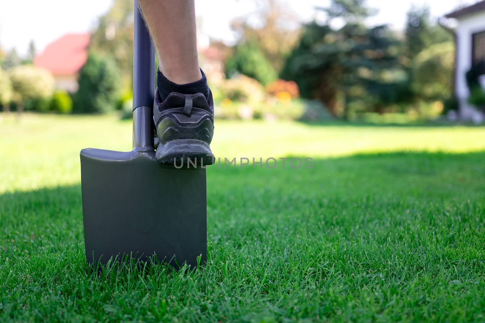 Man works with a shovel in the garden in close-up (copy space)