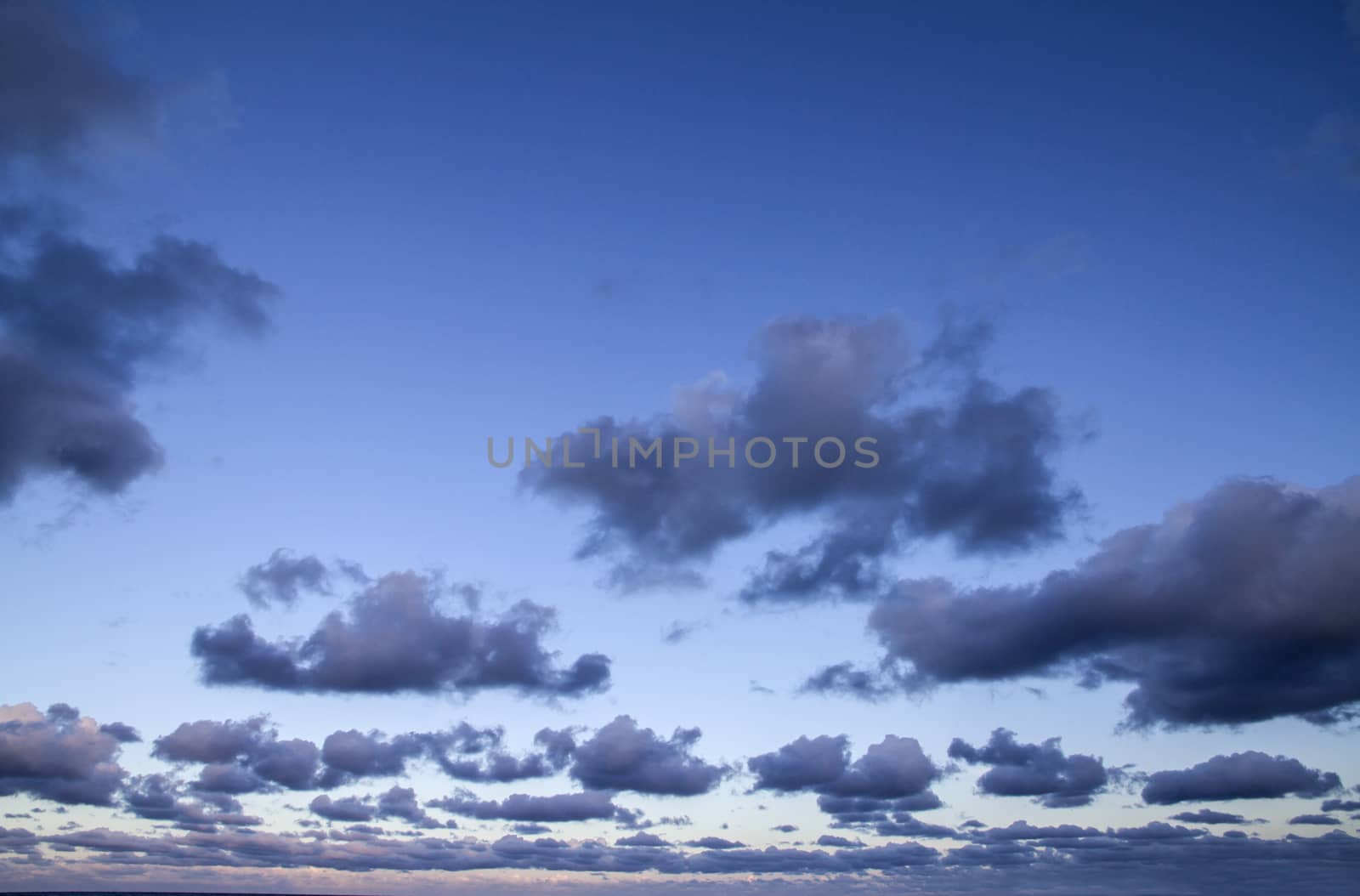 Impressive sky at sunset with layers of clouds tinged with pink  by robbyfontanesi