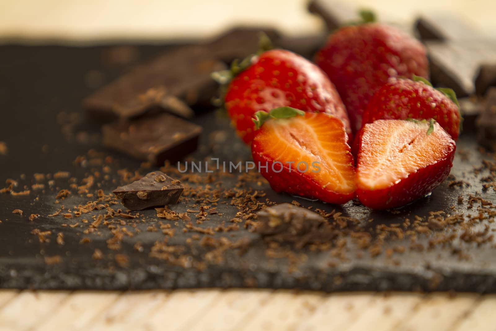 Neatly placed strawberries on a slate plate with chopped chocola by robbyfontanesi