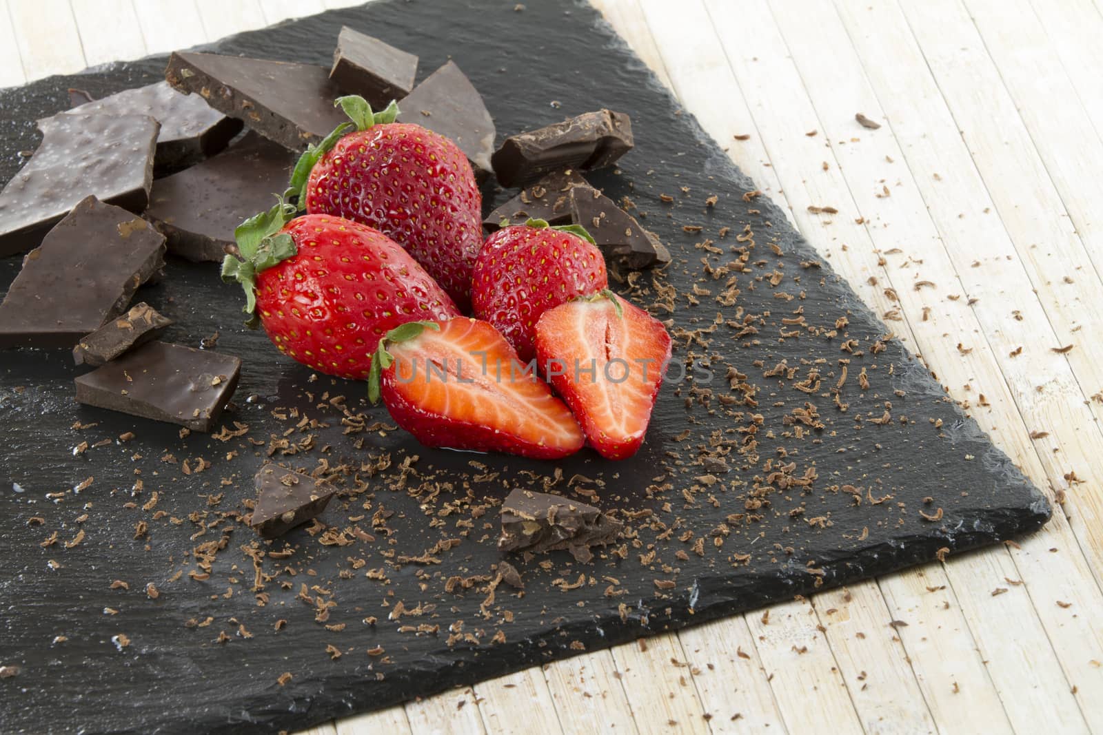 Neatly placed strawberries on a slate plate with chopped chocola by robbyfontanesi