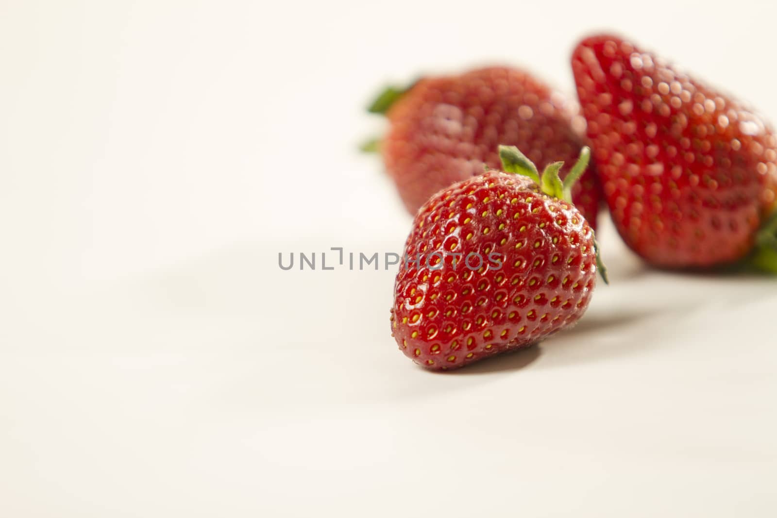 Close-up of three strawberries isolated on white background shot in high angle view with selective focus