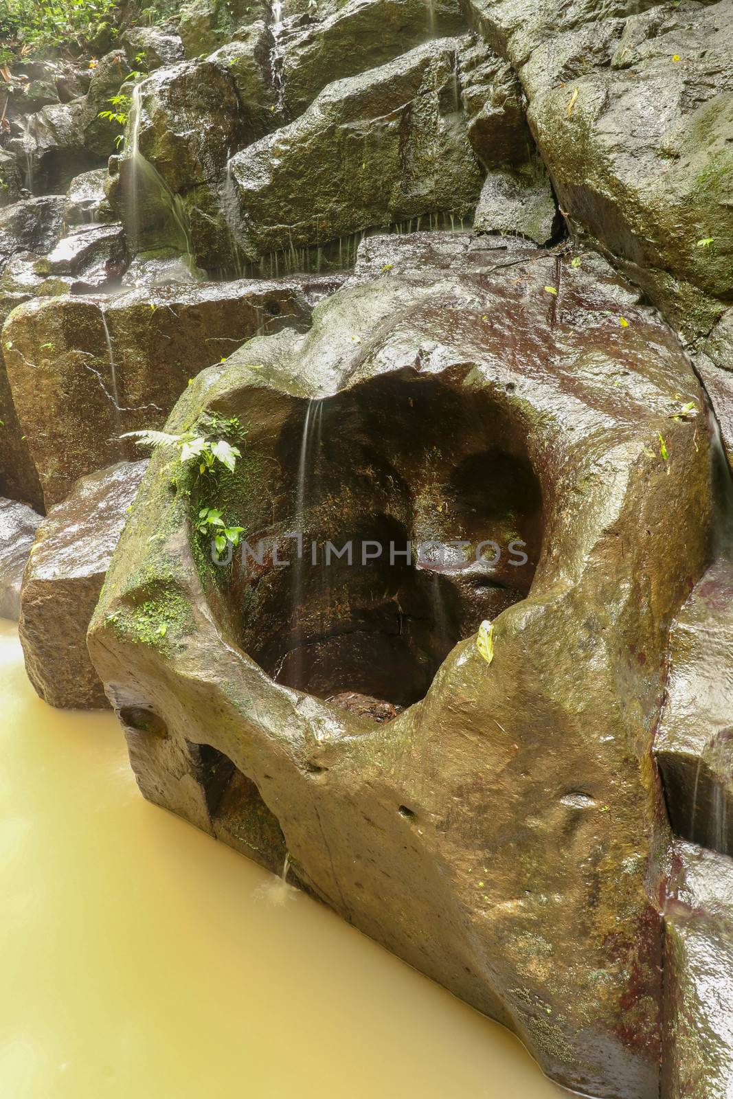 Erosion created hole in the shape of a heart in the rock. A heart shaped gap in the stone of a river bed in Bali, Indonesia.