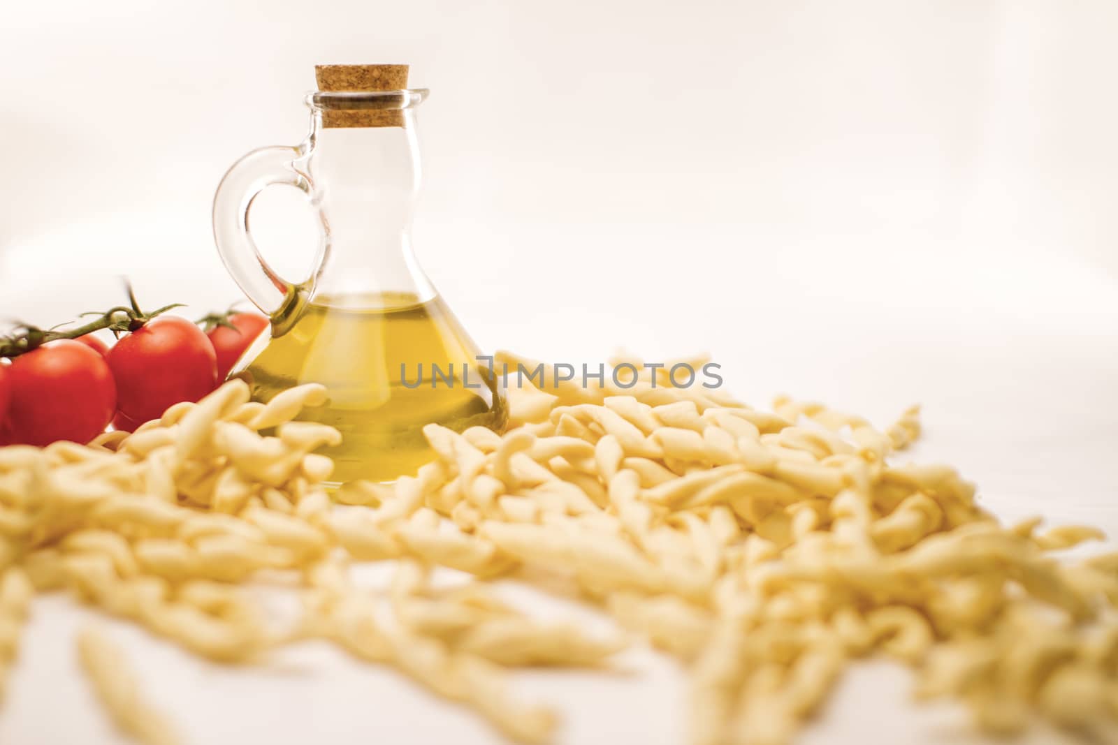 Close up still life of italian handmade pasta fusilli al ferretto with tomato puree and extra virgin olive oil on white background